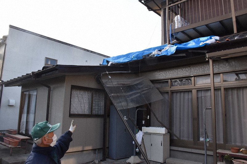 地震で壊れた屋根や雨どいを指さす住民=宮城県山元町坂元地区で2021年2月16日、滝沢一誠撮影