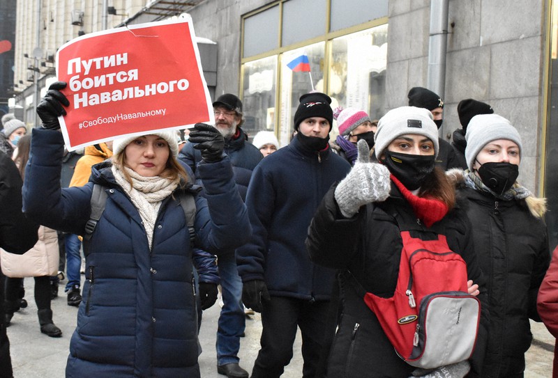 「プーチンはナワリヌイを恐れている」というプラカードを掲げ、抗議デモを行う人々=モスクワで2021年1月23日、前谷宏撮影