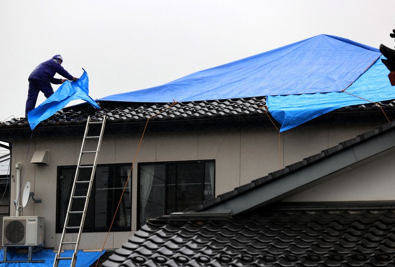 地震で壊れた屋根をブルーシートで覆う住民=福島県相馬市で2021年2月15日、喜屋武真之介撮影