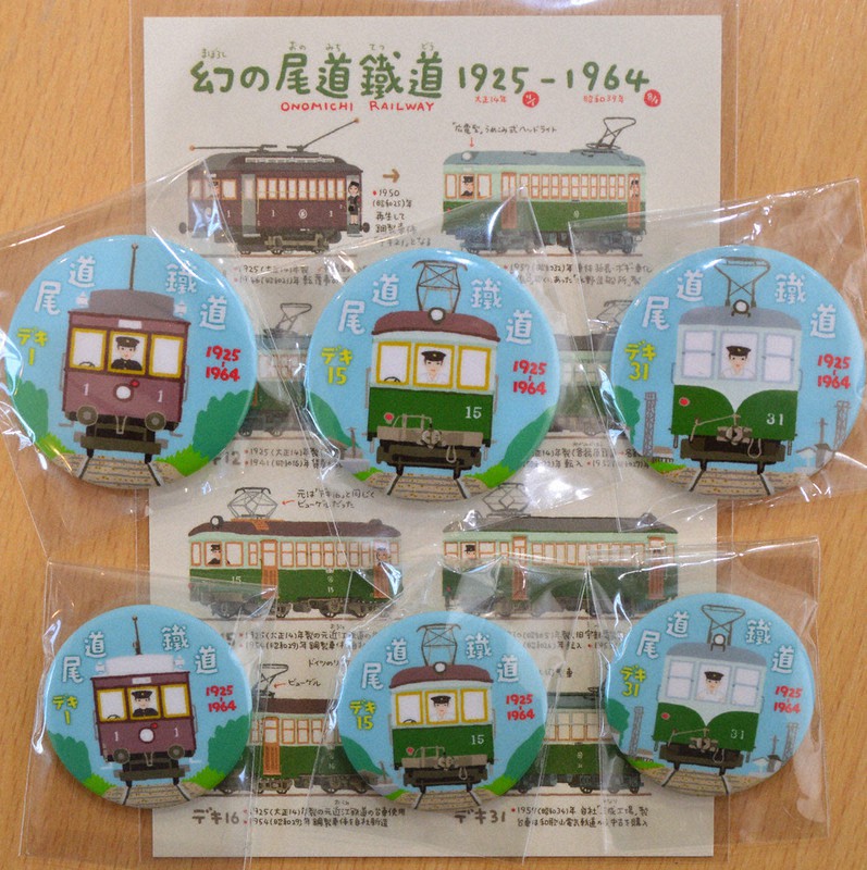 尾道鉄道の車両を描いた缶バッジ(下)と缶マグネット。下は絵はがき=尾道市御調町大田の道の駅クロスロードみつぎで2021年2月20日午後2時34分、渕脇直樹撮影