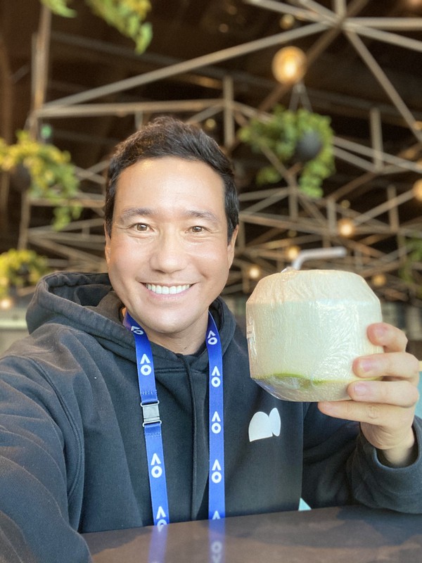 ココナツウオーターを飲む中村豊さん=全豪オープン会場内のカフェで2021年2月(中村さん提供)