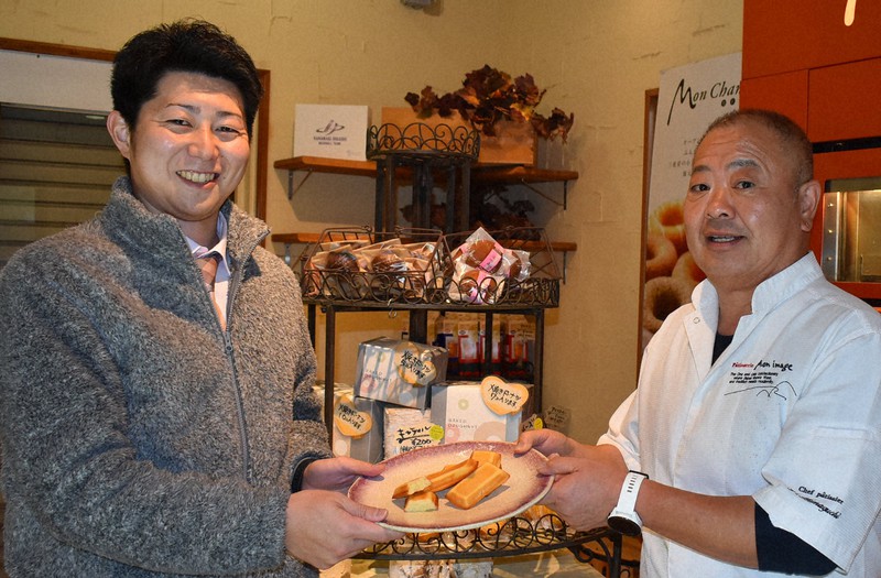 東日本大震災の節目に2人で作った「南部美人フィナンシェ」を手にするパティシェの浜口佳丈オーナー(右)と千葉祐輔さん=熊野市有馬町の「もんいまぁじゅ」で2021年2月17日午後7時35分、下村恵美撮影