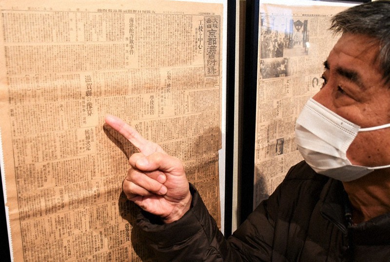 大正10年11月16日付の大阪毎日新聞京都滋賀付録について解説する寺田智次さん。滋賀県予算案や大津市議選について書かれている=大津市本丸町の膳所市民センターで、礒野健一撮影