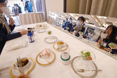 感染防止策を取った模擬パーティーで、鏡越しに会話を楽しみながら食事をする参加者＝奈良市の奈良ホテルで2021年2月22日午後4時23分、望月亮一撮影
