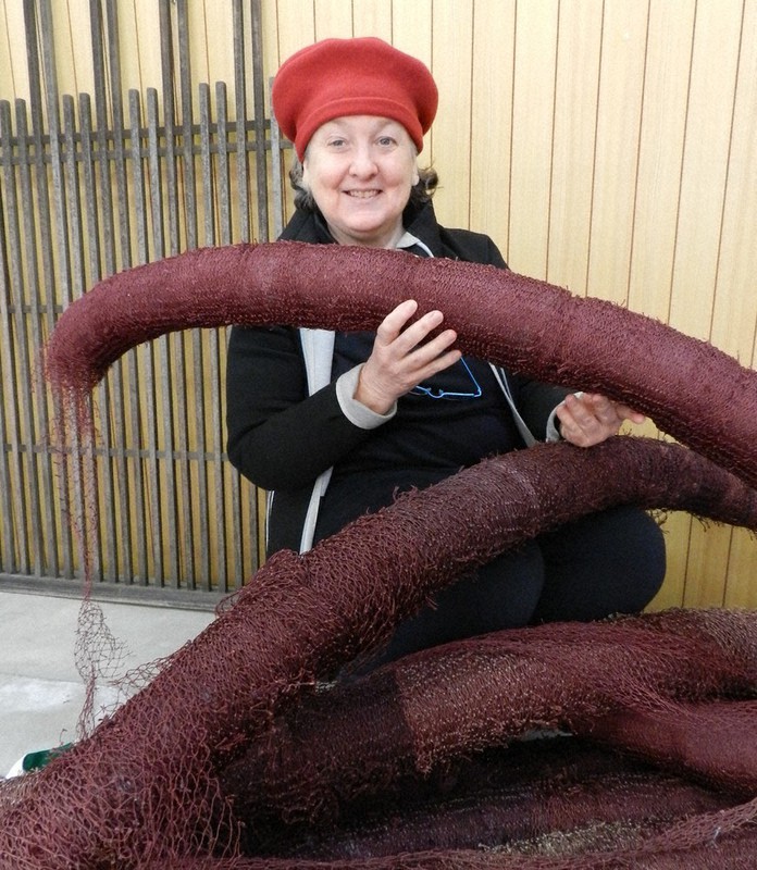 漁網を使った制作中の作品を手にするリンダ・デニスさん=三重県鳥羽市鳥羽の「アートば」で、林一茂撮影
