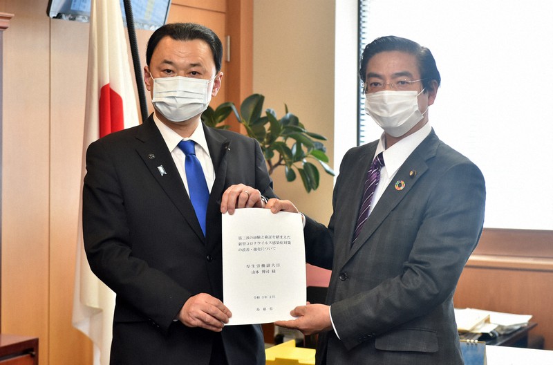 新型コロナウイルス感染症対策の強化などを求める要請書を山本博司副厚生労働相(右)に提出する島根県の丸山達也知事=厚労省で2021年2月25日午前11時半、滝川大貴撮影
