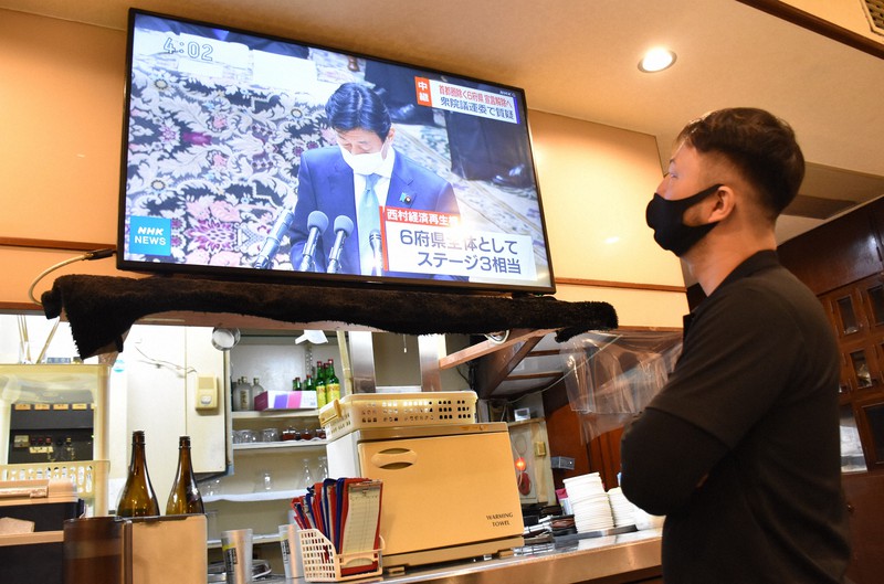 6府県での緊急事態宣言解除に関するテレビ中継を見守る「梅田明月館 堂山店」店長の高山さん=大阪市北区堂山町で2021年2月26日午後4時2分、隈元悠太撮影