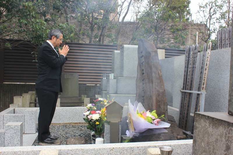 処刑された青年将校らの墓に手を合わせる今泉章利さん。父の義道さんは事件の中心となった青年将校に突然決起を告げられ、部下の兵を守るためにやむなく参加したという=東京都港区元麻布1の賢崇寺で2021年2月26日、栗原俊雄撮影