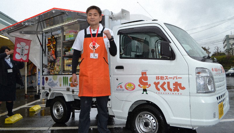 Aコープいまり店で出発式を終え、雨の中で移動販売車「とくし丸」に乗り込む大島さん