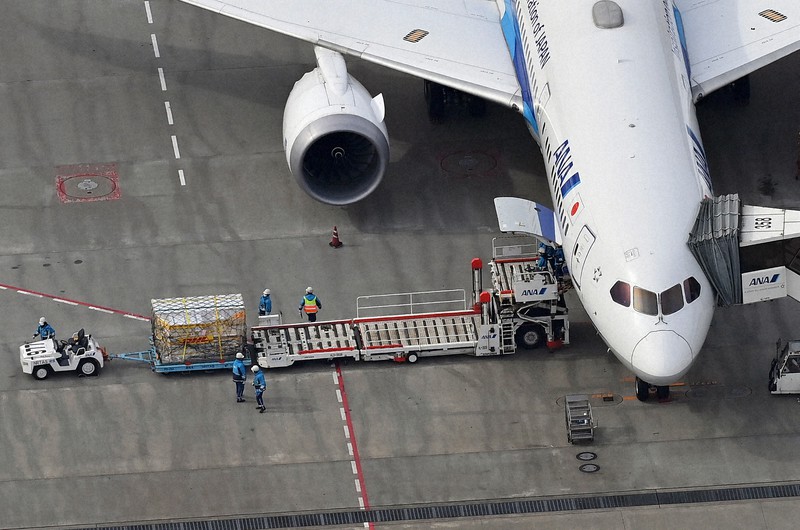 新型コロナウイルス感染症ワクチンを載せた飛行機から降ろされる荷物=千葉県成田市で2021年2月12日午前10時39分、本社ヘリから大西岳彦撮影