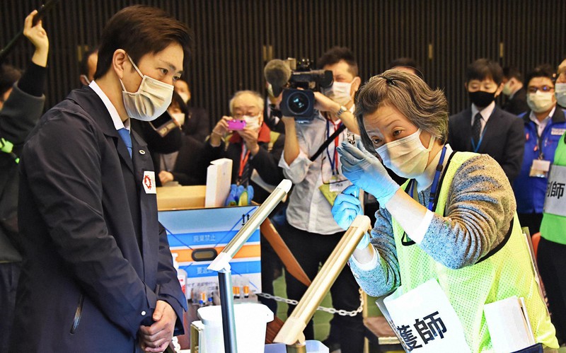 新型コロナウイルスのワクチン集団接種訓練を視察する大阪府の吉村洋文知事(左)=大阪市浪速区のエディオンアリーナ大阪で2021年2月28日、加古信志撮影