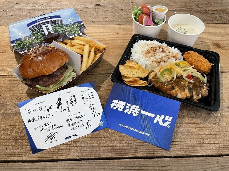 横浜DeNAベイスターズ直営の飲食店が宿泊療養施設に提供した弁当とポストカード=球団提供