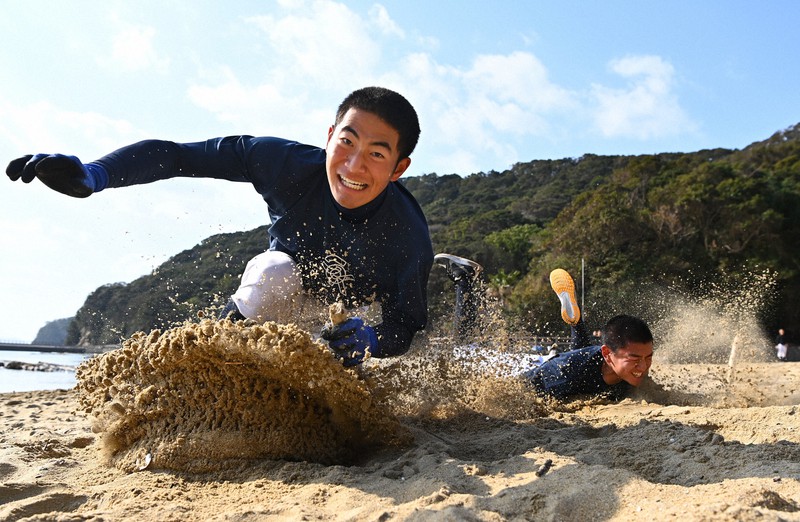 練習場近くの海岸で、砂浜に立てた棒を奪い合う大崎の選手たち=長崎県西海市で、徳野仁子撮影
