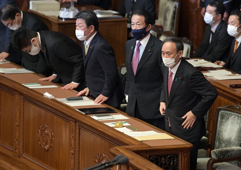 衆院本会議で2021年度予算案が賛成多数で可決し、一礼する菅義偉首相(右)と閣僚ら=国会内で2021年3月2日午後4時35分、竹内幹撮影