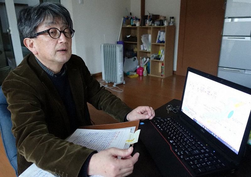 資料やパソコンを見ながら語る石巻日日新聞元報道部長の武内宏之さん=宮城県石巻市で