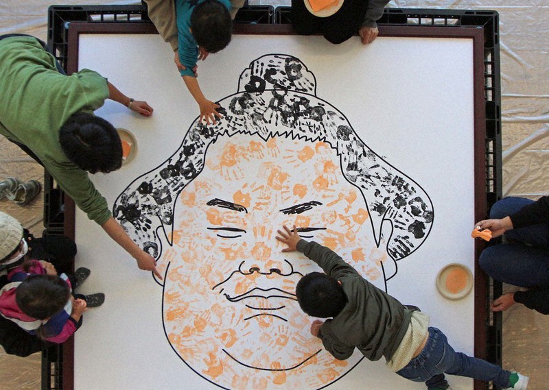 大栄翔の似顔絵に手形を押しつける子供たち=埼玉県朝霞市根岸台のカインズ朝霞店で2021年2月23日、橋本政明撮影