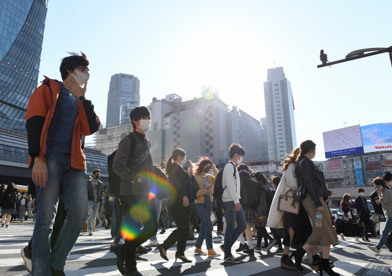 暖かい日差しの中、東京・渋谷のスクランブル交差点を歩く人たち=東京都渋谷区で2021年2月22日、竹内紀臣撮影