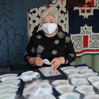 アイヌ文様をあしらったマスクを袋に詰める芳賀美津枝さん＝登別市内で2020年5月25日午後2時5分、平山公崇撮影
