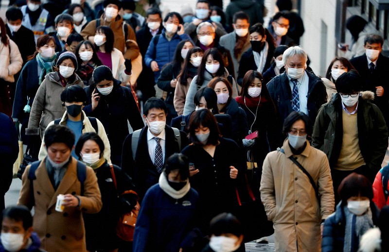 Orang-orang yang memakai topeng dan menuju ke stasiun dengan cepat = Diambil oleh Yuki Miyatake pada tanggal 7 Januari 2021 di Shinjuku-ku, Tokyo