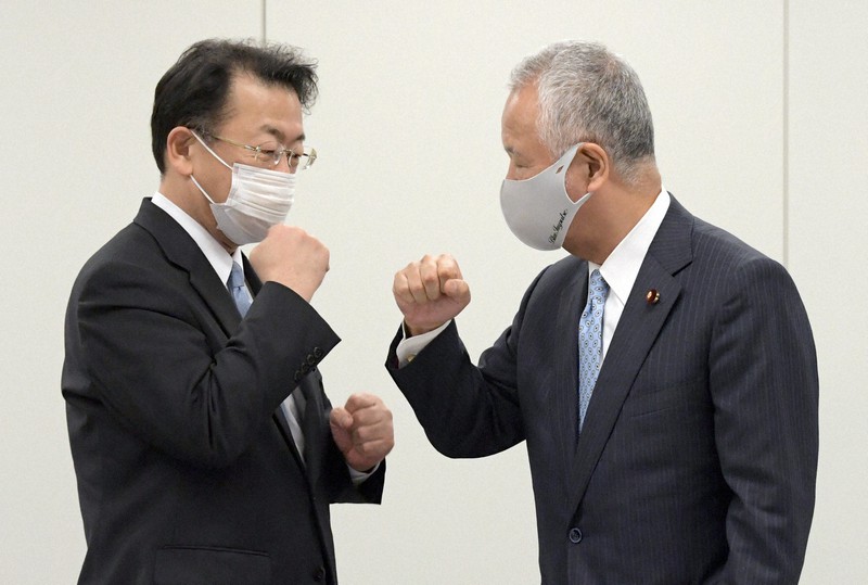 2021年度与党税制改正大綱決定の記者会見後、「グータッチ」をする自民党税制調査会の甘利明会長(右)と公明党税制調査会の西田実仁会長。コロナ禍への対応で負担減につながるメニューが並んだ=衆院第2議員会館で2020年12月10日、竹内幹撮影