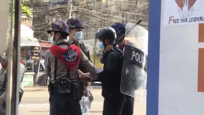 警察に拘束されたAP通信のカメラマンとみられる男性(右から2人目)=ミャンマーのヤンゴンで2021年2月27日、AP