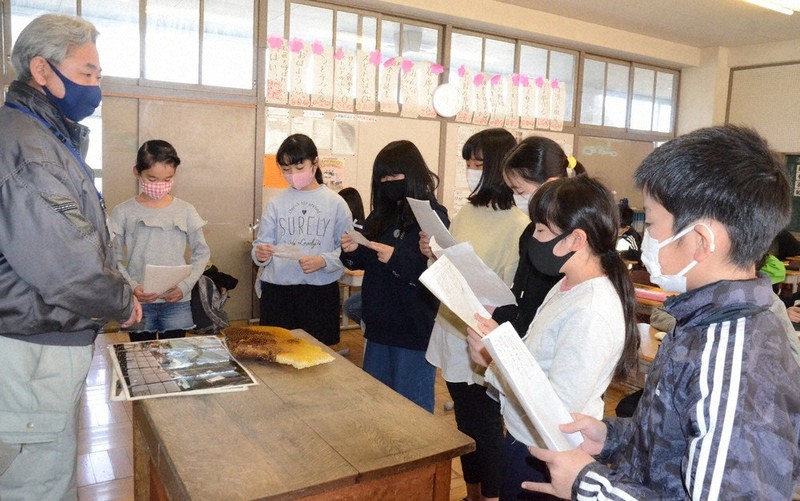 清瀬市職員の海老澤雄一さん(左)に原稿を読み上げる5年2組の児童たち=同市の清瀬小学校で