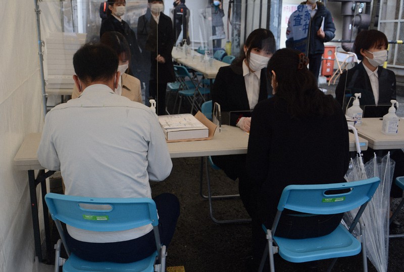 モニタリング検査のスタッフから説明を受ける参加者(手前)=大阪市内で2021年3月5日午前11時10分、石川将来撮影