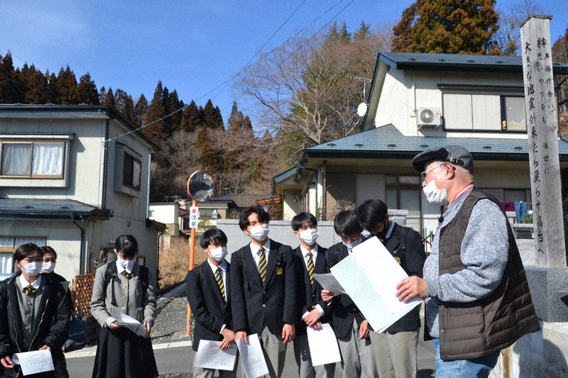 津波で多くの住民が犠牲になった悔しい体験を大槌高校生に伝える小国忠義さん。右側は現在の木碑=岩手県大槌町安渡3で、中尾卓英撮影