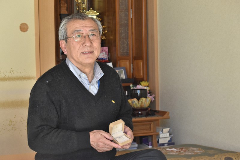 形見の首飾りを手に、亡き妻に思いをはせる佐々木慎一さん=宮城県利府町で2021年3月7日午後0時15分、山田豊撮影