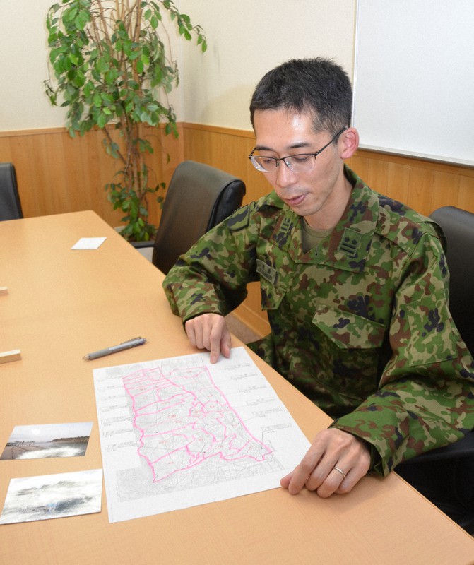 宮城県山元町での作業地図と写真を示し、派遣活動を説明する菅原祐也2佐=宇治市広野町の陸上自衛隊大久保駐屯地で2021年3月2日午後2時18分、鈴木健太郎撮影