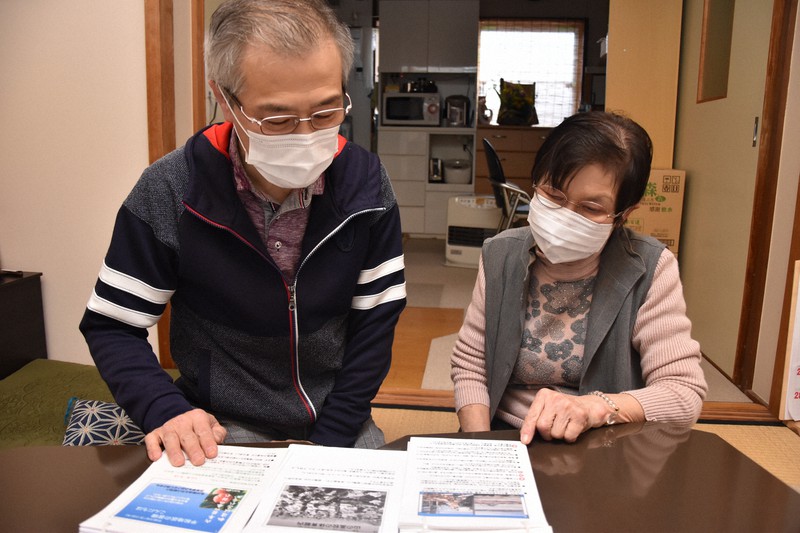 舘孝四さんの残した語り部の資料を見返す妻展子さん(右)と長男松明さん=滋賀県湖南市で2021年3月6日午後3時43分、菅健吾撮影