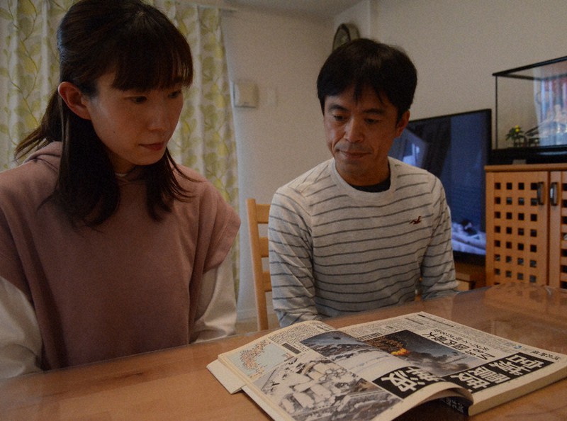 震災当時を伝える新聞の縮刷版を読んで被災体験を振り返る千葉大輔さん、恵美子さん夫妻=北九州市門司区で、宮城裕也撮影