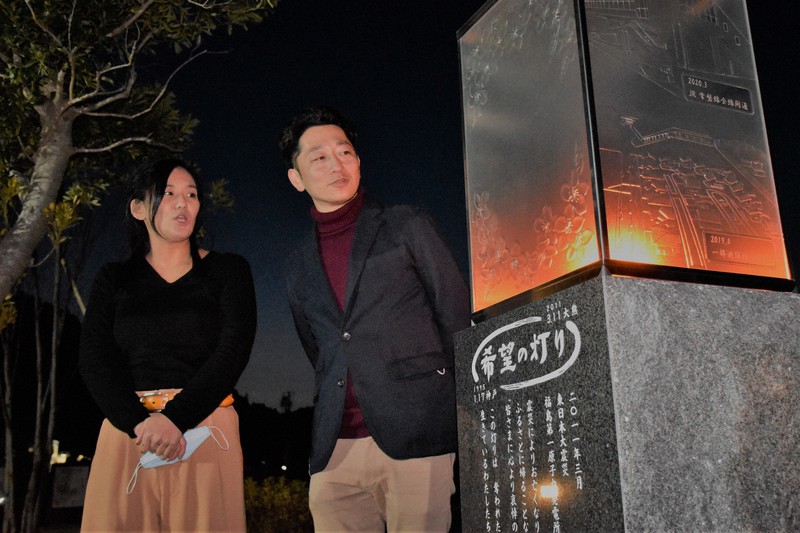 福島県大熊町に分灯された「希望の灯り」を見つめる駒井友美さん(左)とNPO法人阪神淡路大震災「1.17希望の灯り」の藤本真一代表理事=大熊町で2021年3月11日午後6時15分、韓光勲撮影