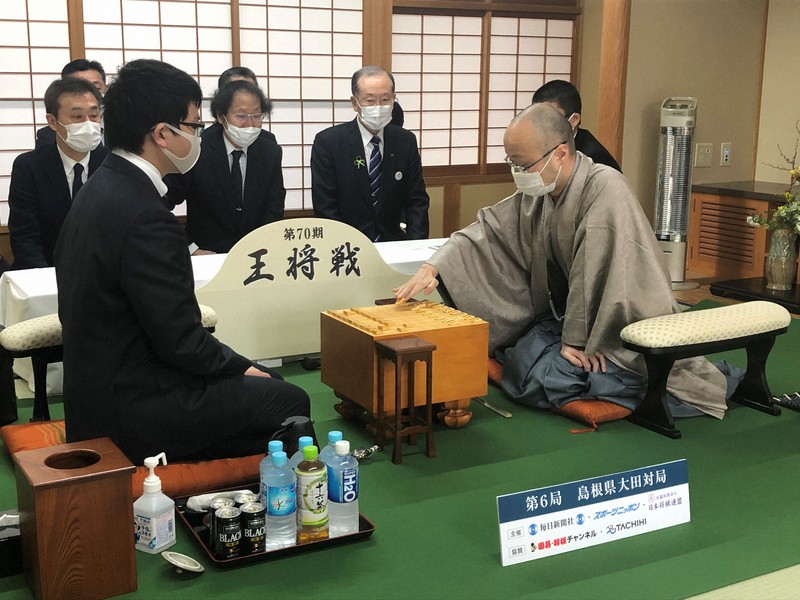 第70期王将戦第6局が始まり、2手目を指す渡辺明王将(右)、手前左は挑戦者の永瀬拓矢王座=島根県大田市のさんべ荘で2021年3月13日、新土居仁昌撮影