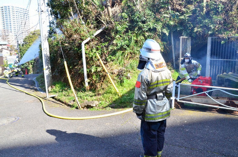 防空壕跡(右奥)にたまった水を使った消火訓練=横浜市西区で