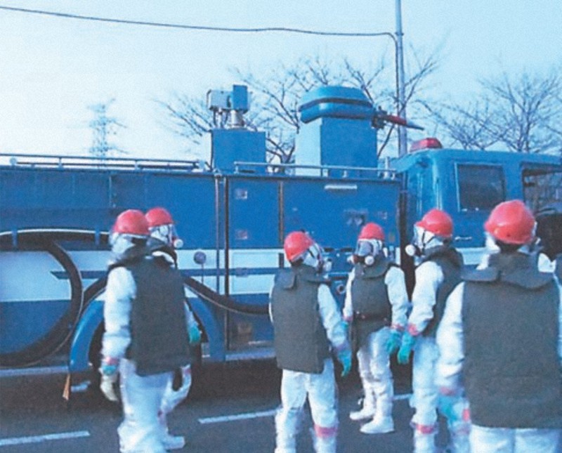 福島第1原発構内で放水作業の準備をする警視庁の機動隊員ら=2011年3月17日午後、警察庁提供