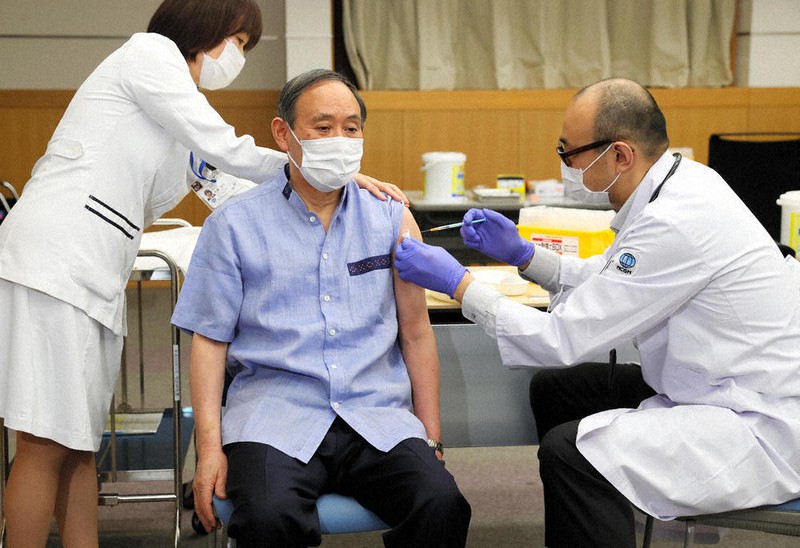 新型コロナウイルスワクチンの1回目の接種を受ける菅義偉首相(中央)=東京都新宿区の国立国際医療研究センターで2021年3月16日午前11時26分(代表撮影)