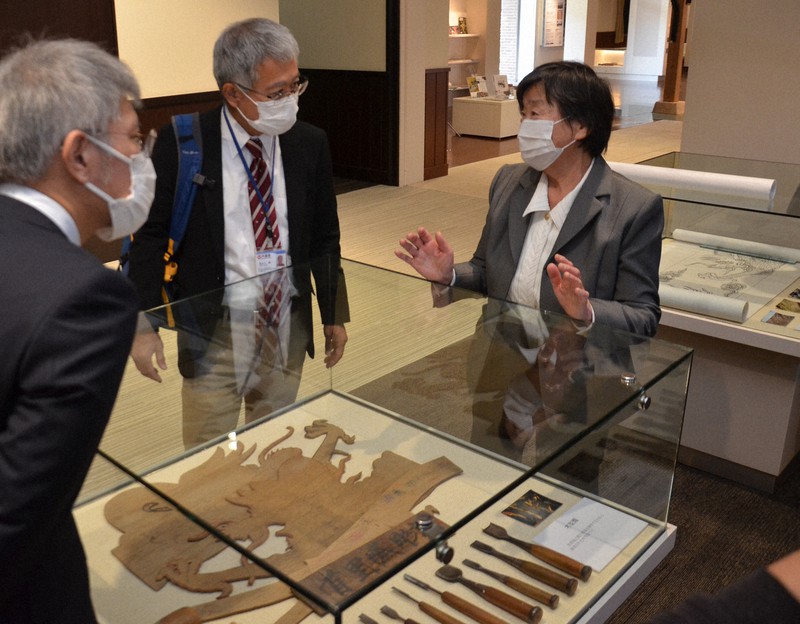 今英男さんの残した資料について沖縄県職員に説明する妻の良子さん(右)=金沢市の石川県立歴史博物館で2021年3月18日午前11時4分、深尾昭寛撮影
