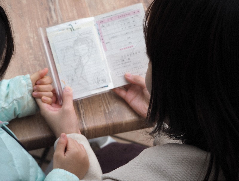 15歳で出産した優子さん(右)。母子手帳には、出産の1週間後に描いた娘の似顔絵を大切に挟んでいる(画像の一部を加工しています)