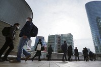 Commuters wearing face masks walk during a rush hour at Shinagawa Station on March 22, 2021, in Tokyo. (AP Photo/Eugene Hoshiko)