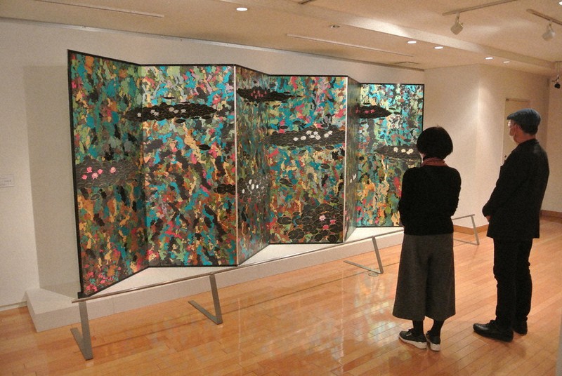 池谷館長が「デザイン性にひかれる」と話す、平松礼二作のびょうぶ。その下図や構想図も展示されている=湯河原町の町立湯河原美術館で