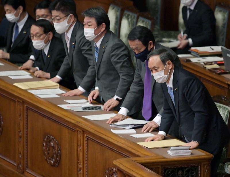 参院本会議で2021年度予算が賛成多数で可決、成立し、一礼する菅義偉首相(右端)と閣僚ら=国会内で2021年3月26日午後5時42分、竹内幹撮影