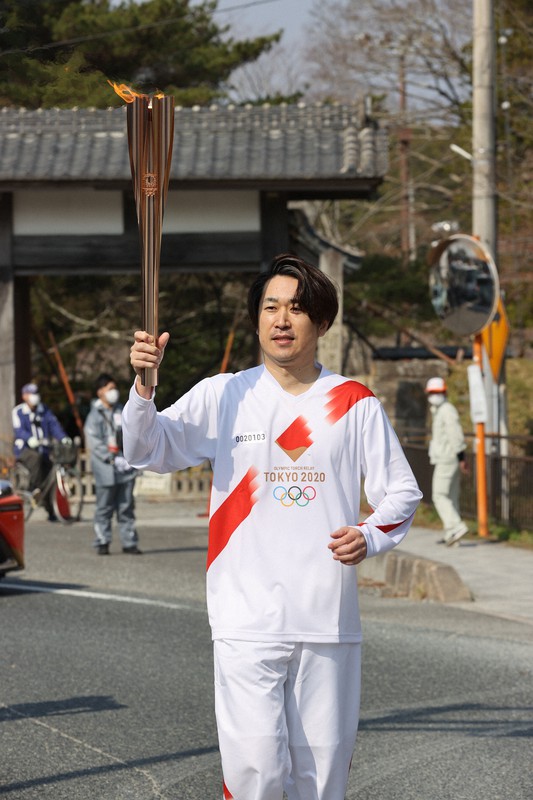 東京オリンピック聖火リレー福島県2日目第1区間を走る鈴木祥高さん=福島県相馬市で2021年3月26日午前9時5分(代表撮影)