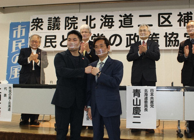 衆院道2区補選で候補者の一本化が決まり、グータッチする松木謙公氏(前列右)と平岡大介氏(同左)=札幌市中央区で2021年3月28日、源馬のぞみ撮影