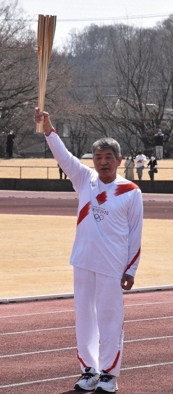 スタート前にトーチを掲げる矢吹正男さん=福島県白河市の白河総合運動公園陸上競技場で2021年3月27日午前11時20分、磯貝映奈撮影