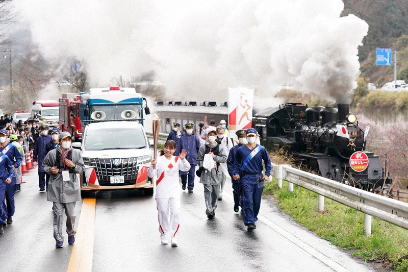 真岡鉄道のSLと並走する野沢綺花さん(中央)=栃木県茂木町で2021年3月28日(代表撮影)