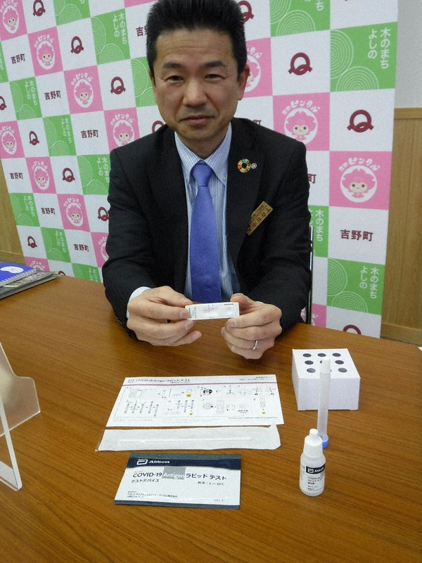 簡易抗原検査キットを使った検査結果を手にする中井町長=奈良県吉野町で、高田房二郎撮影