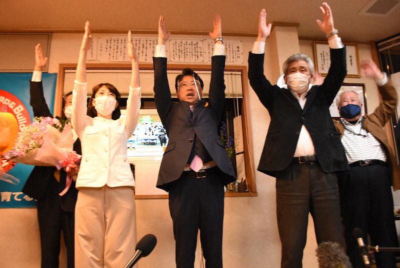 当選を決め、支持者らと万歳する大久保氏(中央)ら=長崎県諫早市で2021年3月28日午後10時21分、中山敦貴撮影