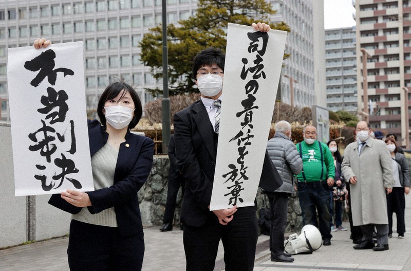 判決を受けて「不当判決」などと書かれた紙を掲げる原告側の弁護士=札幌市中央区で2021年3月29日午後2時29分、貝塚太一撮影