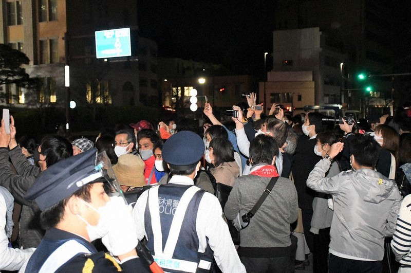 到着式を撮影しようとする人に、警察官らが「立ち止まらないで」などと声をかけていた=宇都宮市で2021年3月29日午後8時10分、玉井滉大撮影